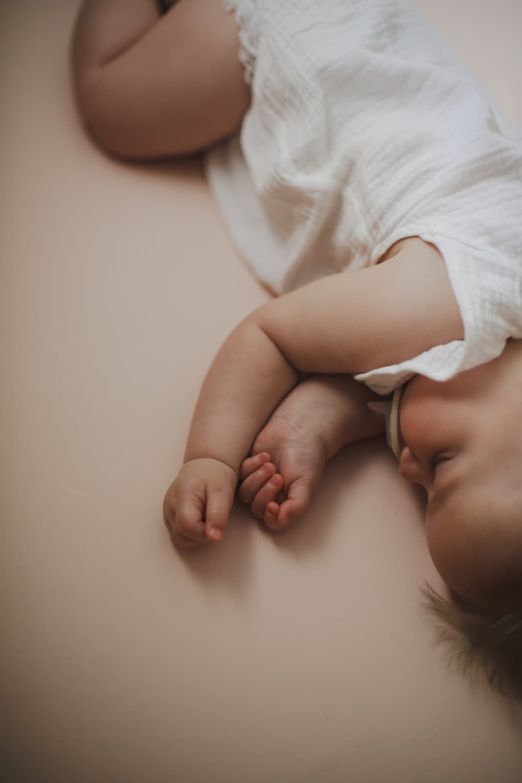A baby sleeping soundly on soft bedding